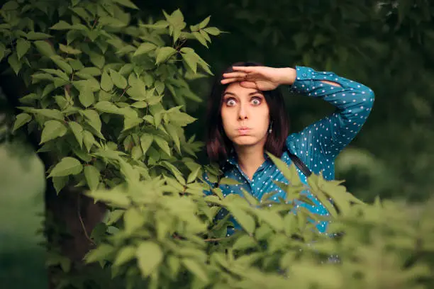 Photo of Curious Jealous Woman Spying from Bushes
