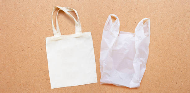 istock White fabric bag with white plastic bag on plywood background. 1162239298