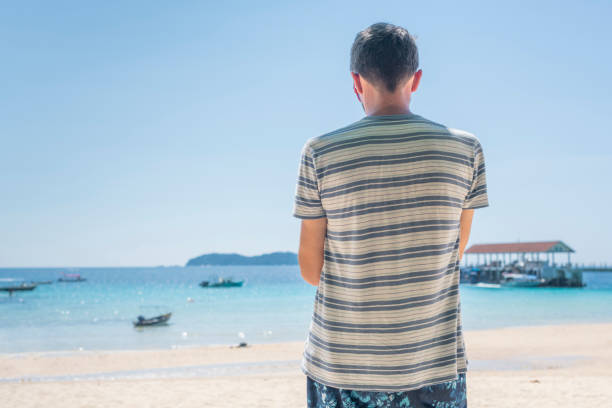 istock A lonely man is looking at the sea 1162241289