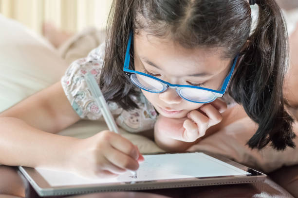 istock Asian school child girl using smart  tablet device digital technology drawing on innovative touchscreen surface 1162241478