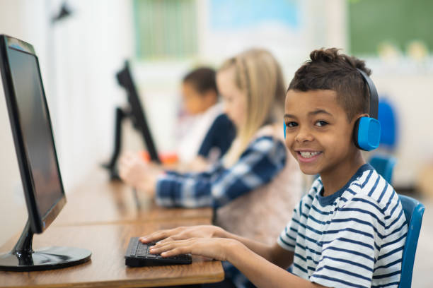 istock Cute little boy sitting at a computer 1162241517