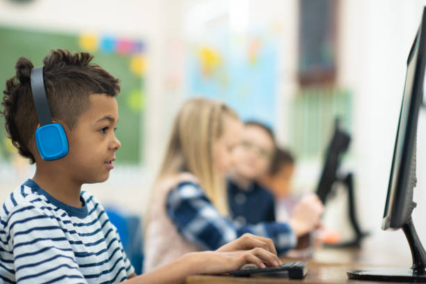 istock Male student wearing headphones in a computer lab 1162241520
