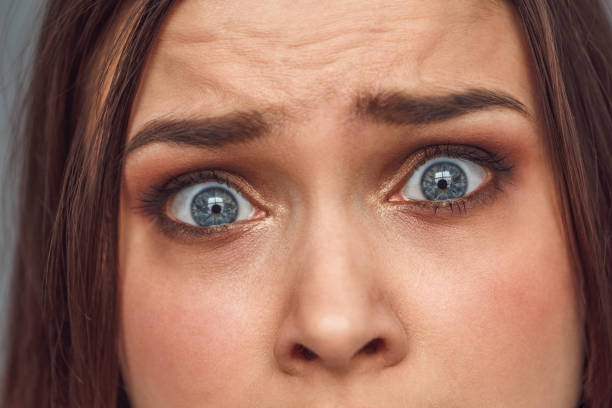 istock Freestyle. Woman standing isolated looking camera frightened close-up 1162242012
