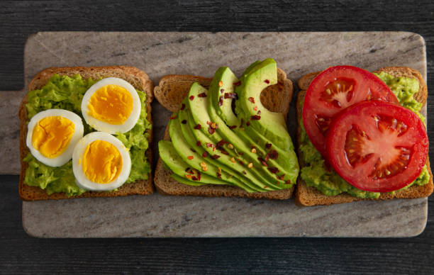 istock Three Varieties of Avocado Toast on a Dark Wood Table 1162245389