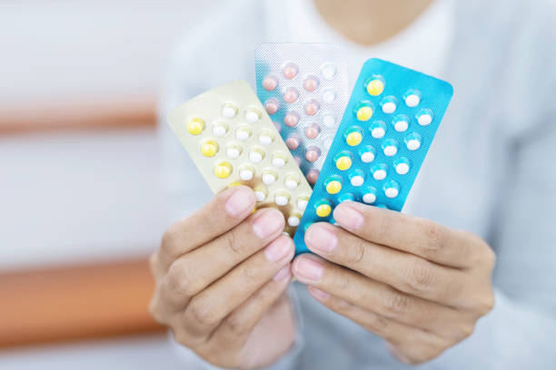 Close up hand contraceptive pill on with colorful pills strips. Contraception reduces childbirth and pregnant concept. Close up hand contraceptive pill on with colorful pills strips. Contraception reduces childbirth and pregnant concept. Ovulation stock pictures, royalty-free photos & images