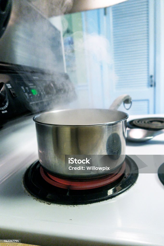 Steaming Pot Of Boiling Water On Red Hot Electric Stove Burner