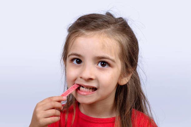 istock Little girl eating sweet candy. 1162252704