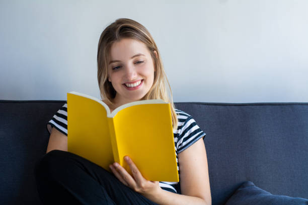 istock Woman reading a book at home 1162252730