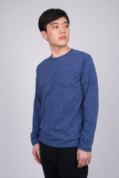 istock Studio shot of young Asian man thinking while looking back 1162256206