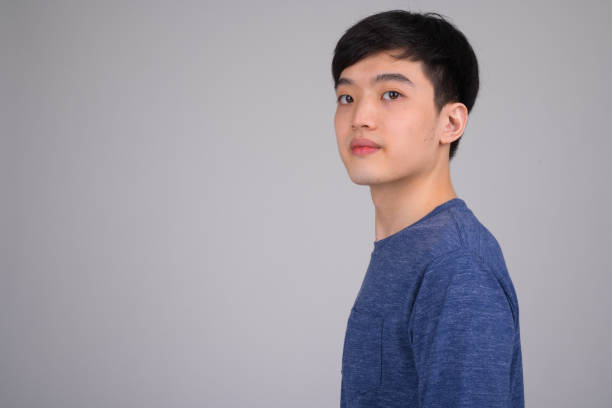 istock Head shot profile view of young Asian man looking at camera 1162256218