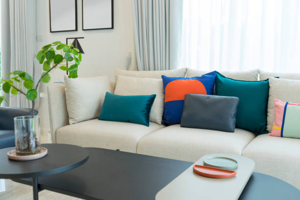 istock Large white sofa with colorful cushions in living room interior 1162260657