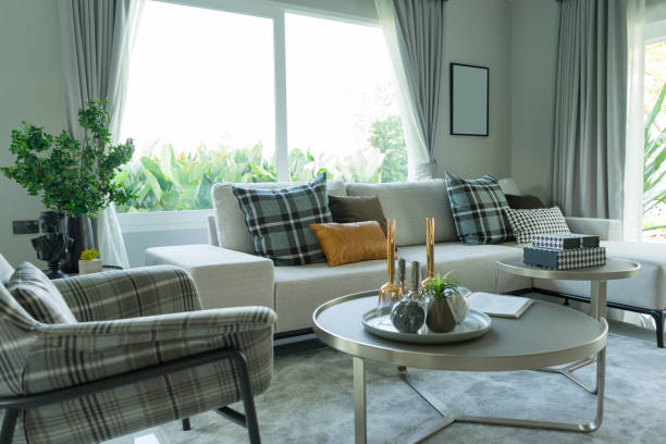 istock modern living room with gray sofa, coffee table and plaid pattern cushions by the big window. 1162261234
