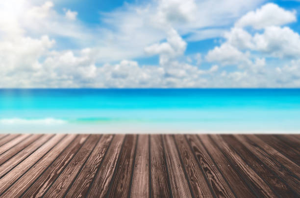 istock Blur tropical beach with bokeh sun light wave on empty old nature wood table abstract background. Product presentation in nature. Vintage tone filter color style. 1162263233