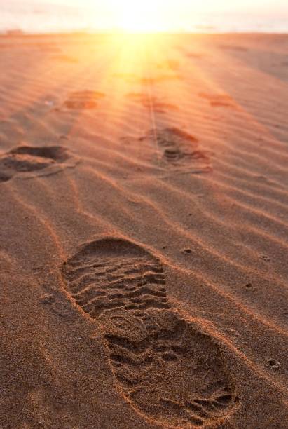 istock human track on a sand in a rays of sand 1162264173