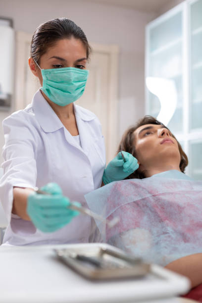 istock Serious middle-aged female doctor taking a dental mirror 1162266341