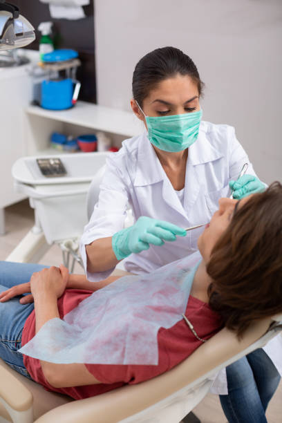 istock Concentrated dark-haired female dentist treating her patients teeth 1162266411
