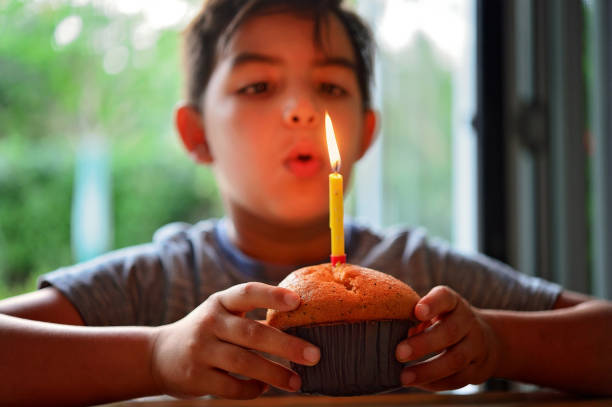 Birthday muffin with candle in hand selective focus