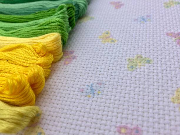 치실의 색깔 된 skeins. 녹색과 노란색 색상의 그늘. 나비 배경 매크로 텍스처 패브릭 캔버스. 바느질, 바느질 및 크로스 스티치용 실. - cross stitch embroidery skeins thread 뉴스 사진 이미지