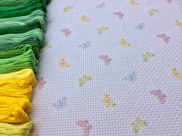치실의 색깔 된 skeins. 녹색과 노란색 색상의 그늘. 나비 배경 매크로 텍스처 패브릭 캔버스. 바느질, 바느질 및 크로스 스티치용 실. - cross stitch embroidery skeins thread 뉴스 사진 이미지