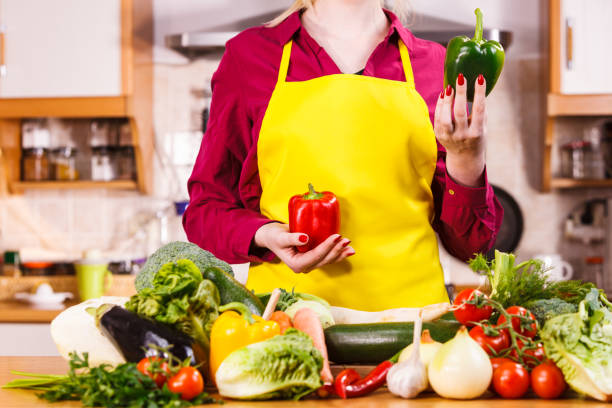 istock Woman holding two bell peppers 1162270458