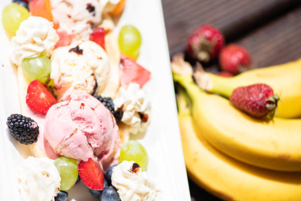 Plate of healthy fresh fruit salad with ice cream on the wooden background. Plate of healthy fresh fruit salad with ice cream on the wooden background. bananas, frozen berries, and applesauce into her non-dairy ice creams stock pictures, royalty-free photos & images