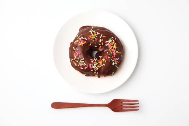 istock chocolate frosted doughnut on plate on white background 1162272577