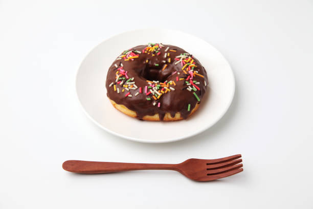 istock chocolate frosted doughnut on plate on white background 1162272619