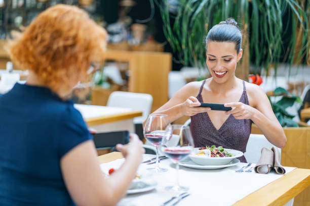 istock Two girlfriends dining and taking photos  in restaurant 1162273544