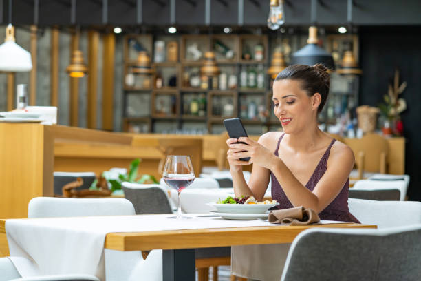 istock Woman sitting in restaurant and using smart phone 1162273546