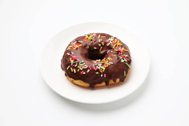 istock chocolate frosted doughnut on plate on white background 1162273644