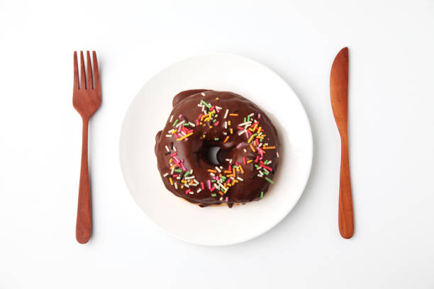 istock chocolate frosted doughnut on plate on white background 1162273677