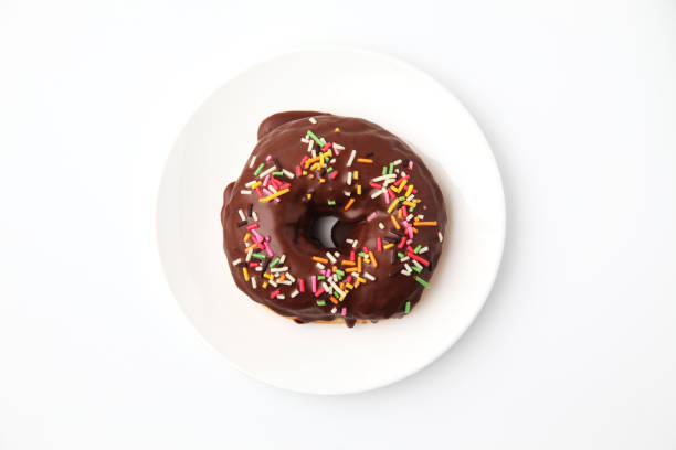 istock chocolate frosted doughnut on plate on white background 1162273749