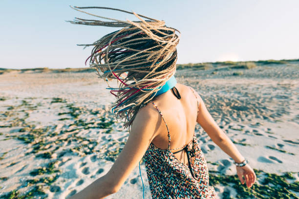 Low angle view of a mature woman jogging on a beach.