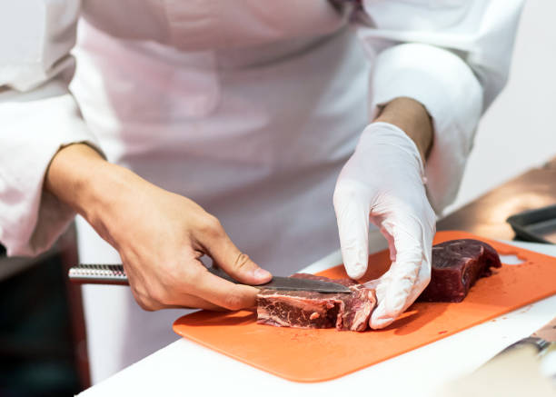 istock Chef cutting fresh raw meat with knife in the kitchen, Chef cutting beef on a board 1162276157
