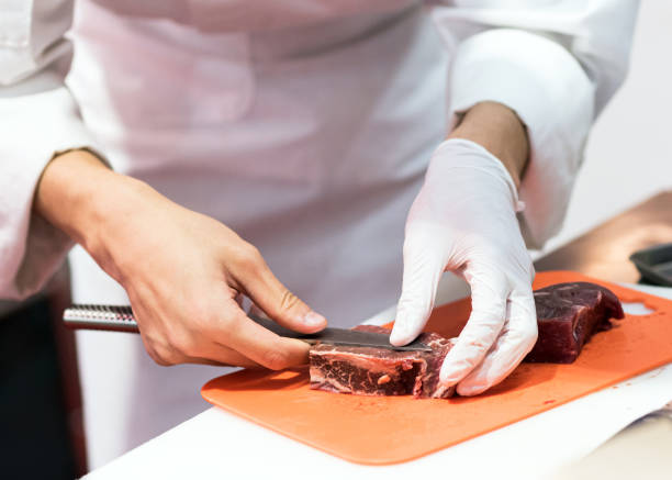 istock Chef cutting fresh raw meat with knife in the kitchen, Chef cutting beef on a board 1162276160