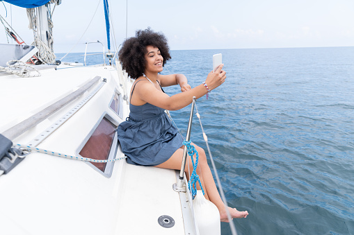 Afro Woman yachtning and taking selfie , enjoying summer vacations.