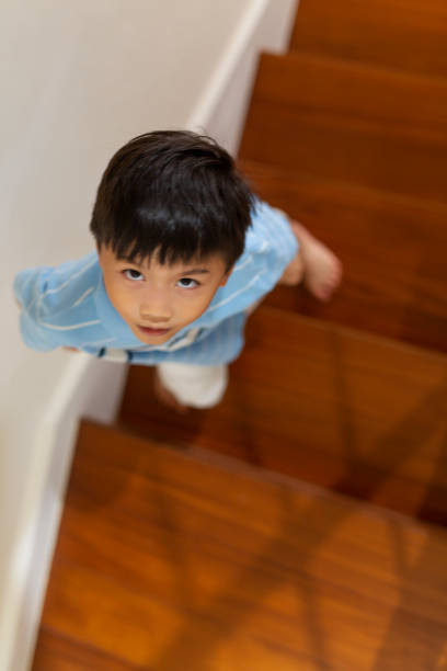 istock Little Boy Looking Up From On Stairs 1162279473