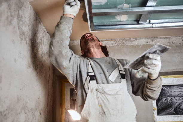 istock Construction worker plastering gypsum walls inside the house. 1162284192
