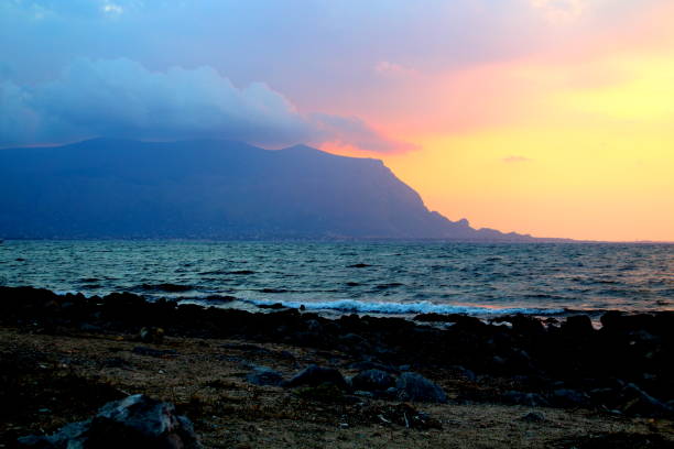 istock sunset over the sea with promontory in the background 1162284194