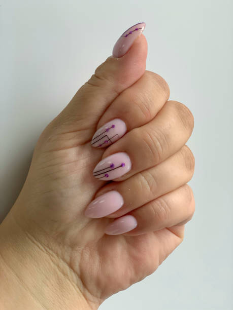 istock Pink manicure with with black geometric pattern on almond-shaped nails on white background 1162284615