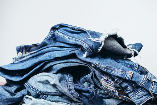 Stack of jeans on table. Zero vaste concept. Ecology and recycling.