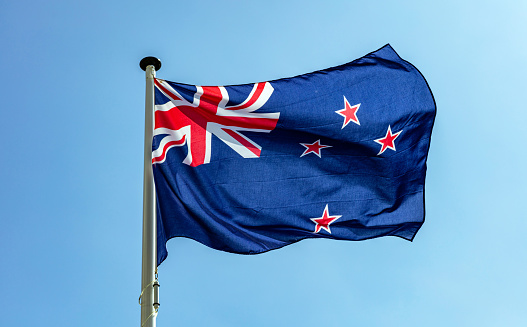 New Zealand flag waving against clear blue sky