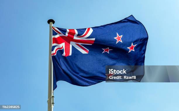 New Zealand Flag Waving Against Clear Blue Sky Stock Photo - Download Image Now - New Zealand Flag, New, Zeeland