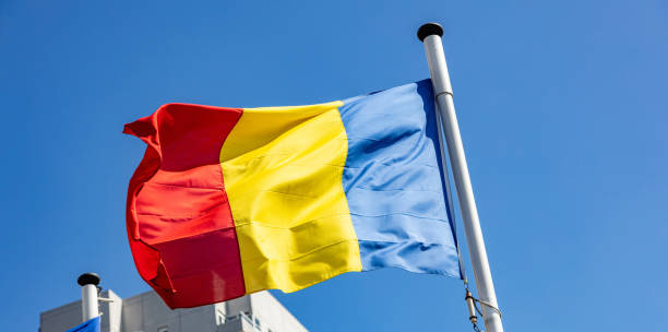 istock Romania flag waving against clear blue sky 1162285826