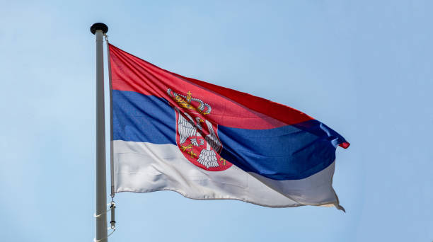 istock Serbian flag waving against clear blue sky 1162285843