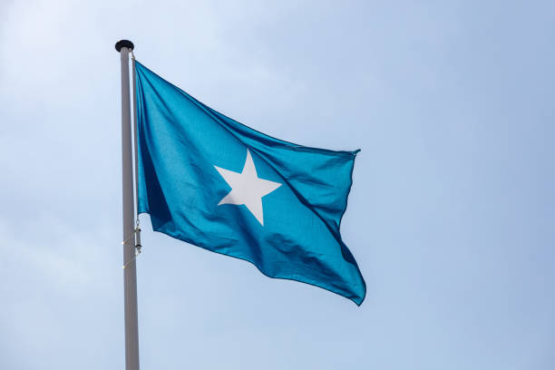 Somalia flag waving against clear blue sky stock photo