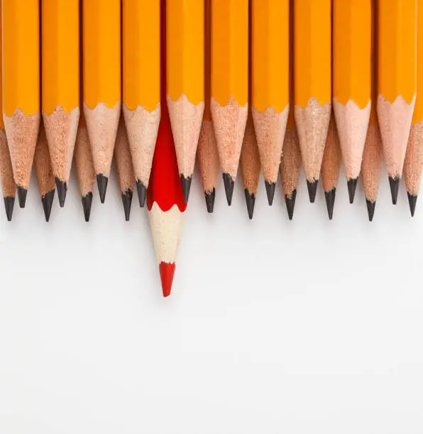 Photo of One red pencil in group of similar ones