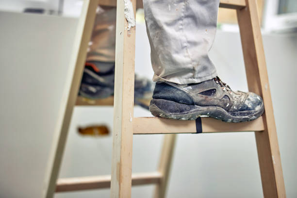 istock Worker standing on the ladder and renovating house. 1162286853