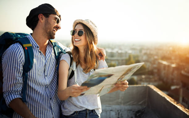 pareja joven que viaja con un mapa en la ciudad - viaje fotografías e imágenes de stock