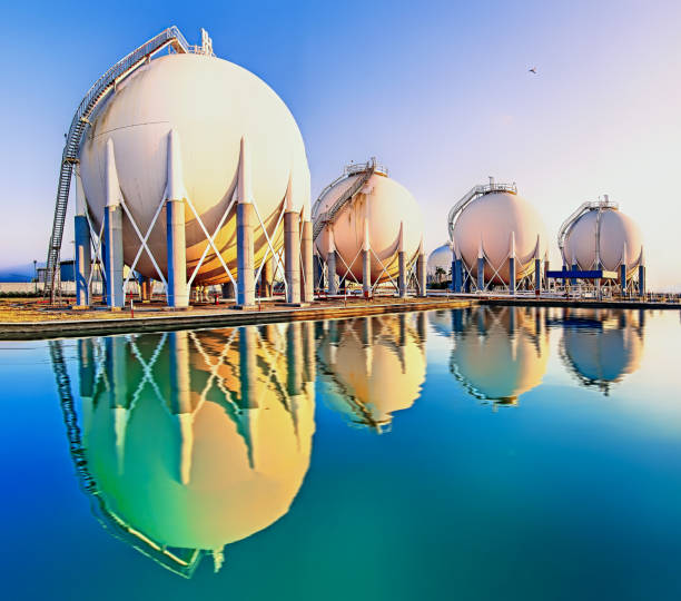 tanques de gas esfera y reflejos sobre el agua en la planta de refinería - distillation tower fotografías e imágenes de stock